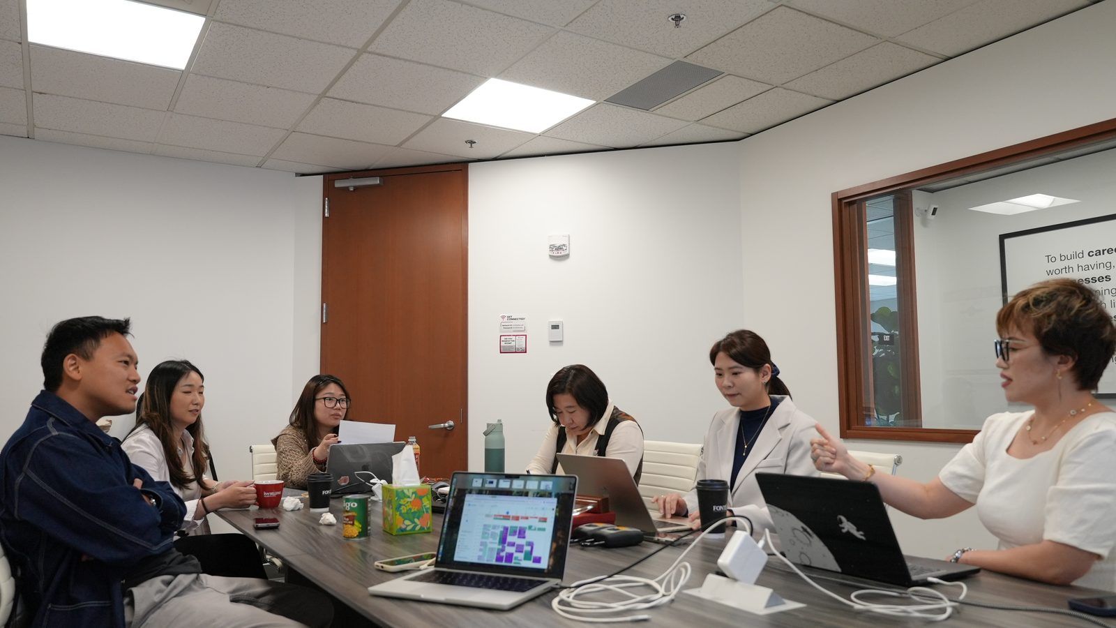 Maggie Sun Real Estate agents reviewing Seattle and Eastside market data in a team briefing